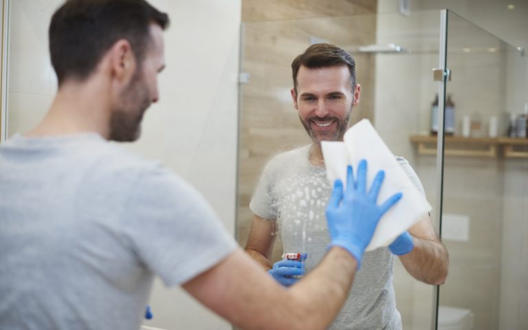 Happy man cleaning his home